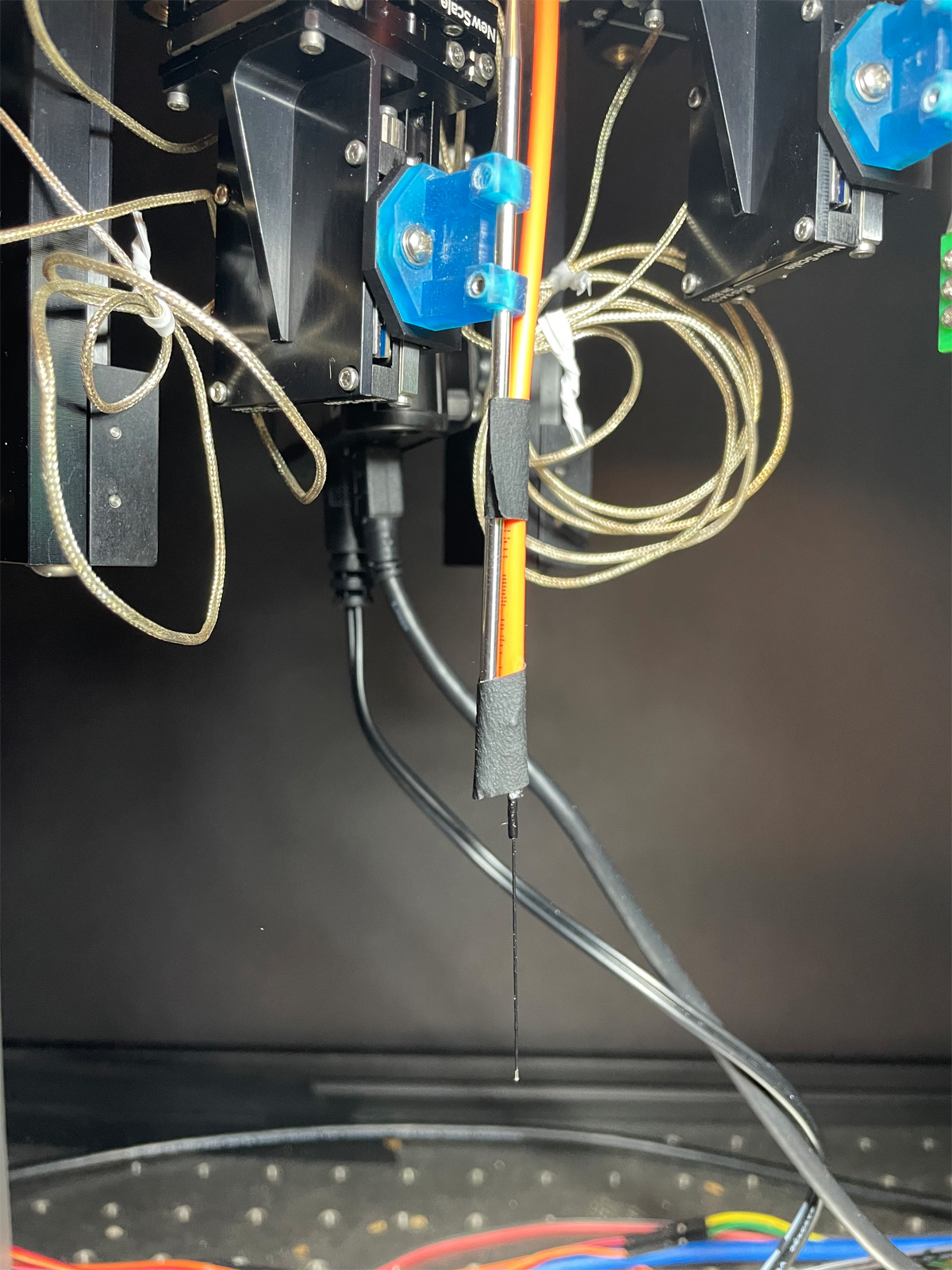 Photo by Y. Kate Hong, the Hong Lab, Carnegie Mellon University shows a positioner in the New Scale MPM System with a bare-tipped optical fiber taped to the steel reference probe 